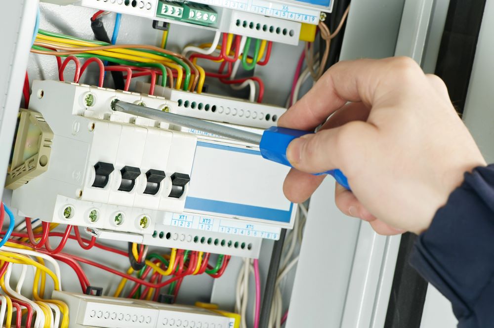 Close-up image of an electrician at work, featuring Anderson Lighting & Electric and highlighting expert electrical panel repairs