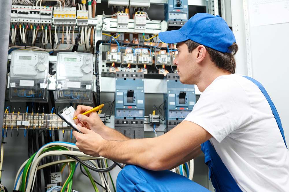 Image of a repair man at work, featuring Anderson Lighting & Electric and highlighting comprehensive maintenance and repair services for electrical systems.