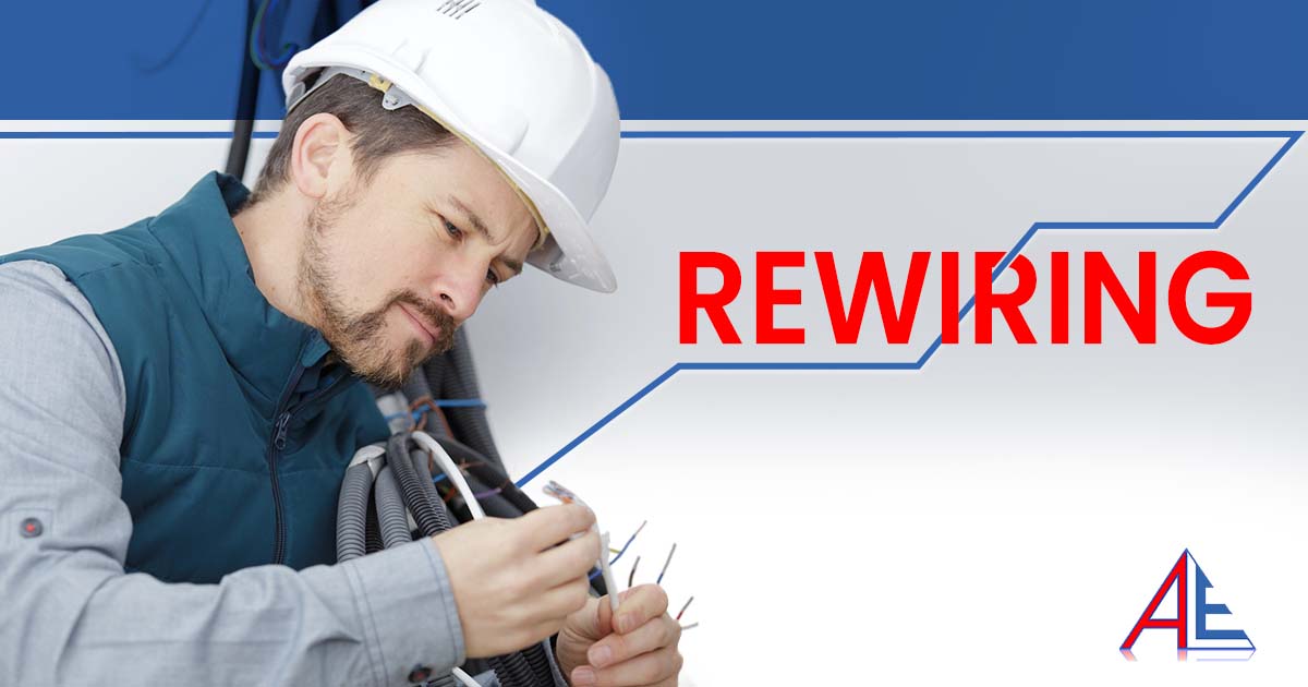 Image of a young male electrician examining wiring, featuring Anderson Lighting & Electric and highlighting professional rewiring services for safe and updated electrical systems.