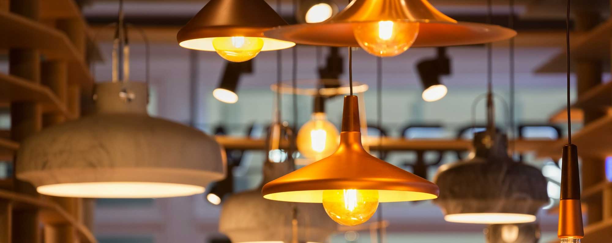 Warm Copper Pendant Lighting Display Copper and stone pendant lights hanging in a modern café with warm Edison bulb lighting